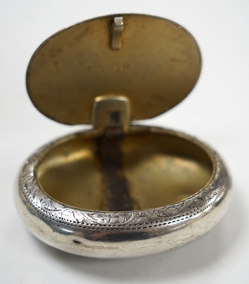 An Edwardian engraved silver oval tobacco box, Hilliard & Thomason, Birmingham, 1901, 75mm. Condition - poor to fair